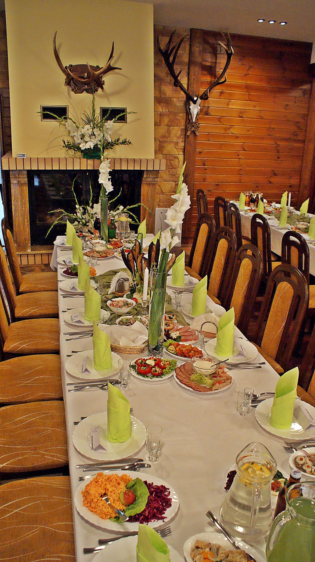 Large banquet hall with wooden beams, draped ceiling decorations and tiled dance floor